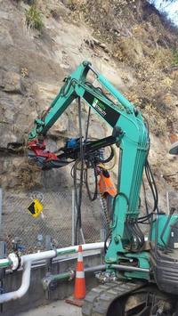 Excavator mounted rock drill