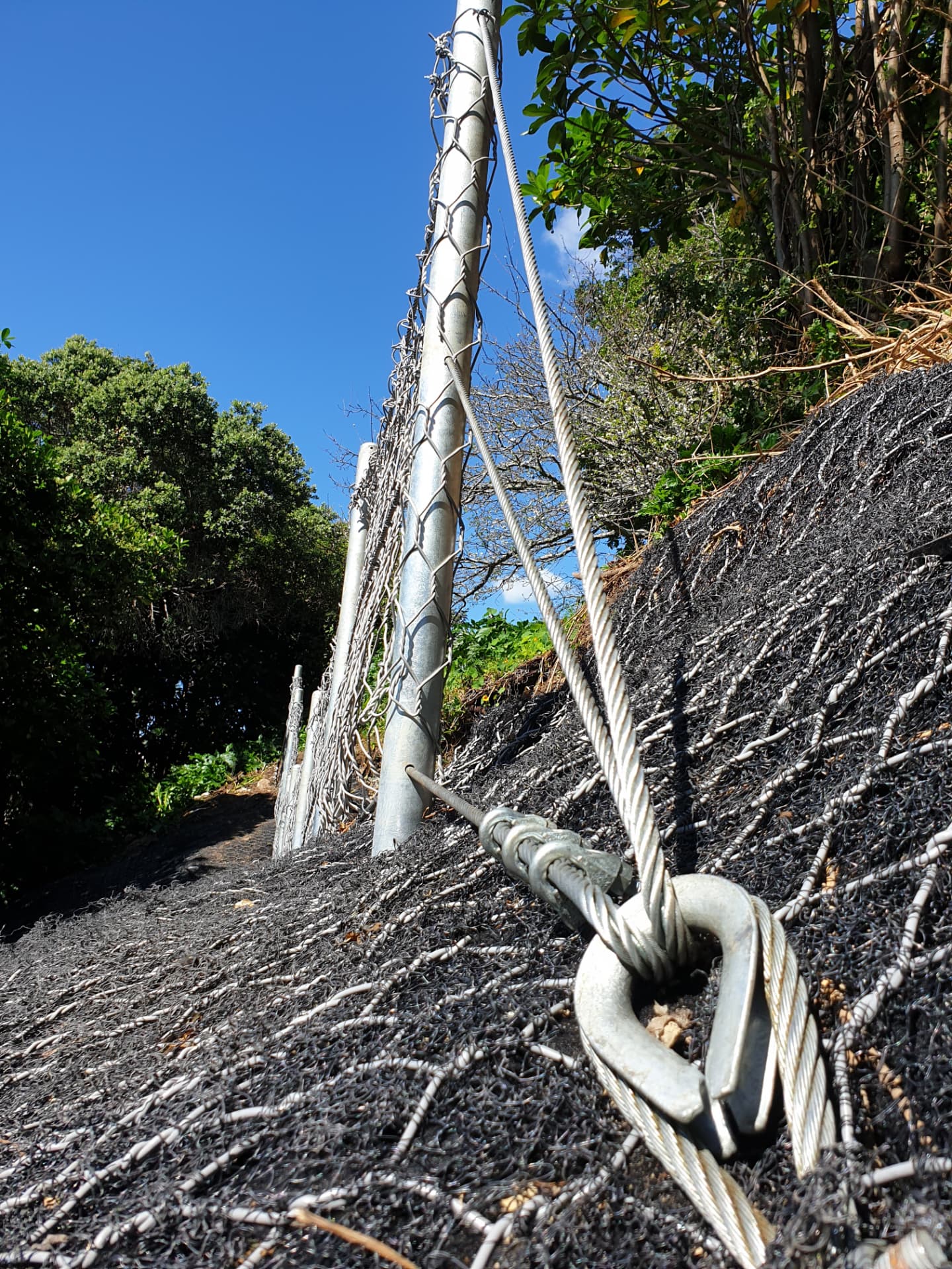 Anchored cable and mesh detail on a catch fence installation