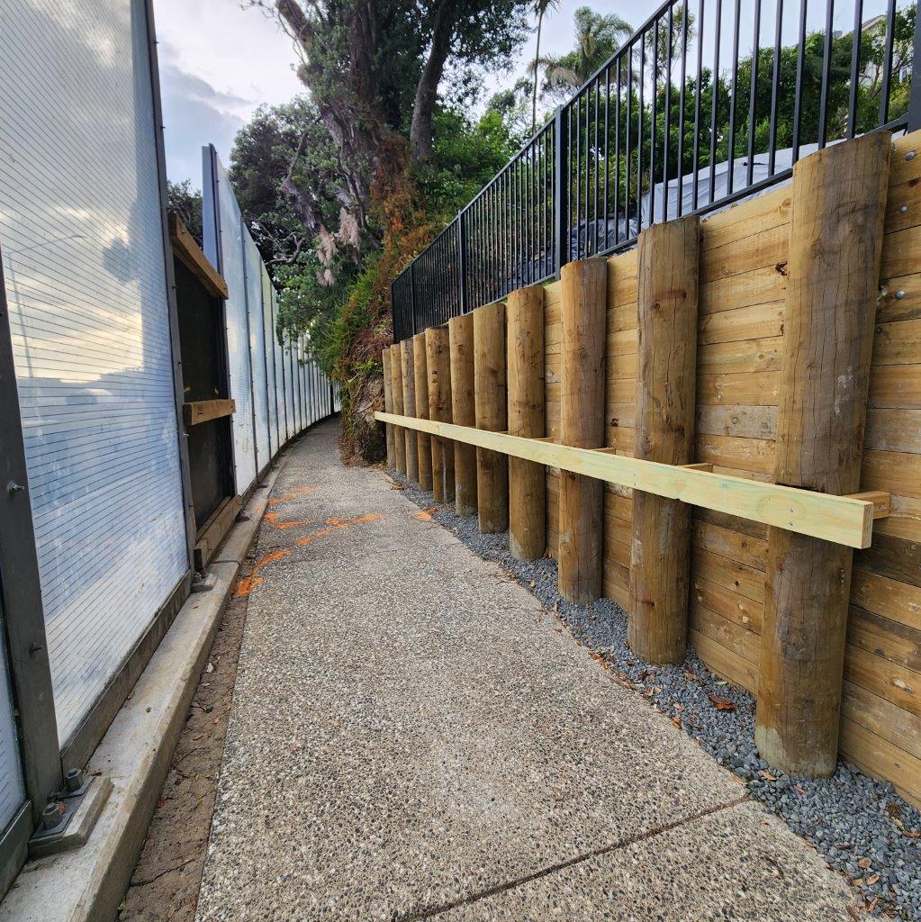 Timber pole retaining wall under construction