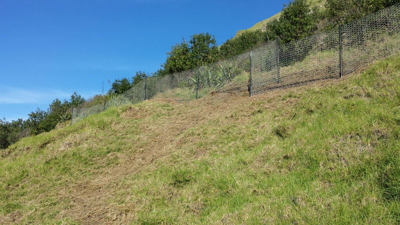 Catch fence traversing a pastoral hillside