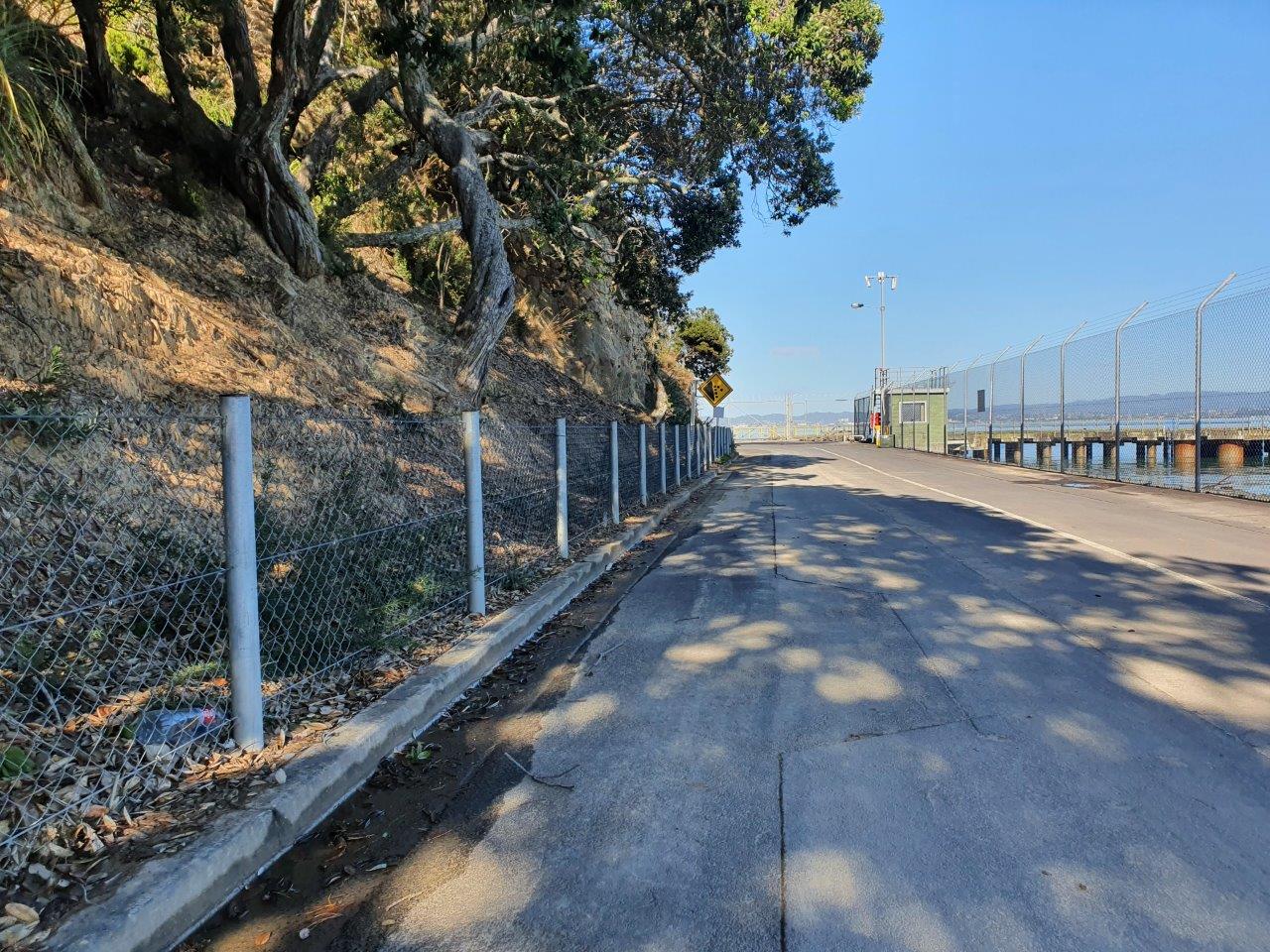 Mesh catch fence protecting a coastal road beneath a cliff